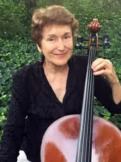 A woman holding a cello in her hands.