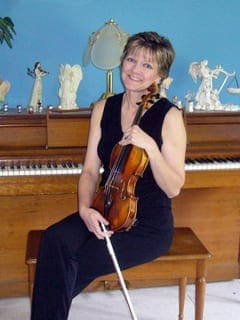 A woman wearing a black dress and holding a violin